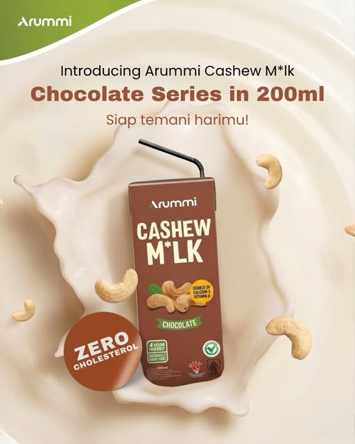 Arummi Chocolate carton, brown with a green Chocolate label, on a splash of milk with cashews.